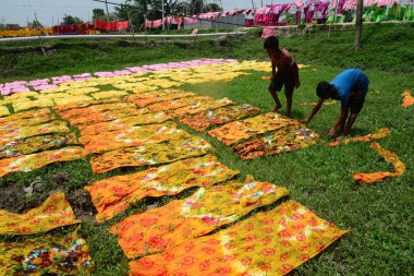 Bangladeşli çocuk işçi Dhaka yakınlarındaki Narsingdi bölgesinde Batik kumaş sektöründe güneş altında bezeler kurur, Bangladeş, Nisan 'da 26, 2018. Her Işçi par gün 400-500 taka veya 5-6 ABD doları kazanır.