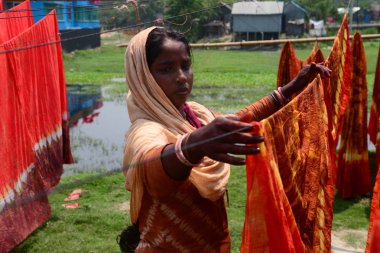Bir Bangladeşli kadın işçisi Dhaka yakınlarındaki Narsingdi bölgesinde Batik kumaş sektöründe güneş altında bezeler kurutur, Bangladeş, Nisan 'da 26, 2018. Her Işçi par gün 400-500 taka veya 5-6 ABD doları kazanır.