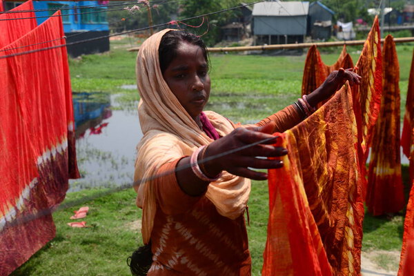 A Bangladeshi woman worker dries clothe under the sun in the Batik Cloth industry at Narsingdi area near Dhaka, Bangladesh, on April 26, 2018. Each Worker earns par day 400-500 Taka or 5-6 US Dollar.