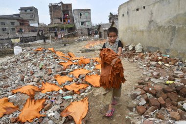 Bir Bangladeşli çocuk çalışanı 8 Nisan 2017 Dhaka bir tabakhane işlenmiş deri parçaları kurur. 
