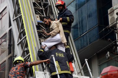 Dakka, Bangladeş'te 28 Mart 2019 üzerinde yanmış bir ofis insanlardan Bangladeşli İtfaiye kurtarma. En az 25 kişi öldü ve 70 kişi de Dhaka içinde ofis binası patlak bir yangında yaralandı.