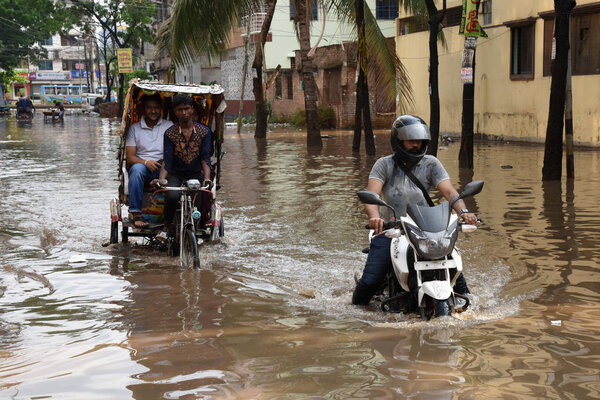 Vehicles and Rickshaws try driving with passengers through the waterlogged streets of Dhaka after heavy rainfalls caused almost-standstill, in Bangladesh. On April 02, 2019 