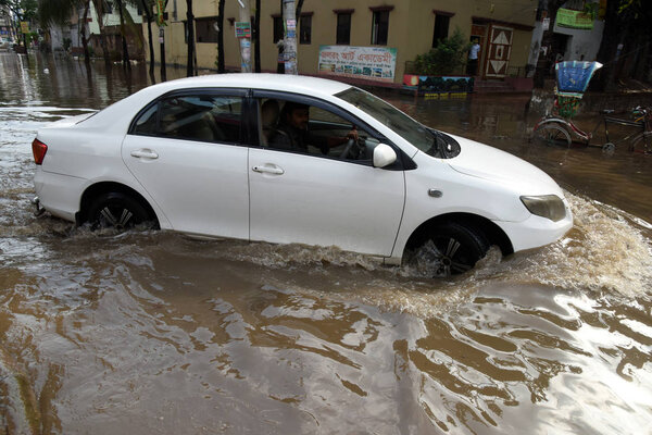 Vehicles and Rickshaws try driving with passengers through the waterlogged streets of Dhaka after heavy rainfalls caused almost-standstill, in Bangladesh. On April 02, 2019 