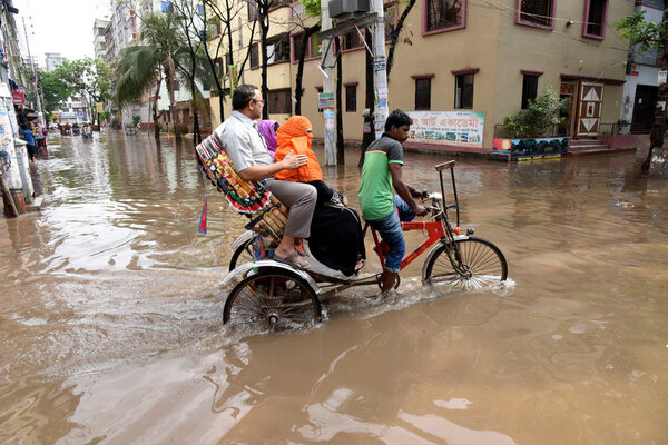 Vehicles and Rickshaws try driving with passengers through the waterlogged streets of Dhaka after heavy rainfalls caused almost-standstill, in Bangladesh. On April 02, 2019 