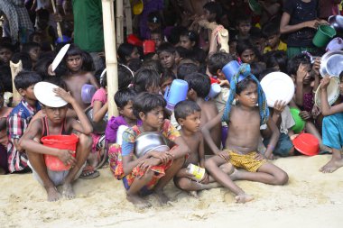 Rohingya mülteci çocukları, 2006 Ekim 'inde Bangladeş, Cox' s Bazar 'daki Palongkhali derme çatma kampında yiyecek toplamak için bekliyor. Birleşmiş Milletler Mülteciler Yüksek Komiserine (UNHCR) göre 525.000 'den fazla Rohingyalı mülteci fro firar etti