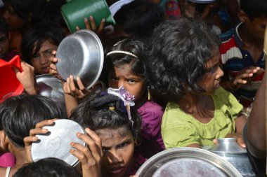 Rohingya mülteci çocukları, 2006 Ekim 'inde Bangladeş, Cox' s Bazar 'daki Palongkhali derme çatma kampında yiyecek toplamak için bekliyor. Birleşmiş Milletler Mülteciler Yüksek Komiserine (UNHCR) göre 525.000 'den fazla Rohingyalı mülteci fro firar etti
