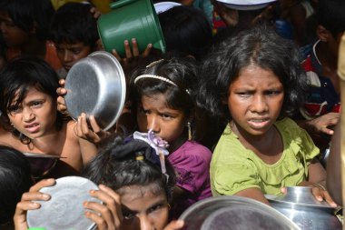 Rohingya mülteci çocukları, 2006 Ekim 'inde Bangladeş, Cox' s Bazar 'daki Palongkhali derme çatma kampında yiyecek toplamak için bekliyor. Birleşmiş Milletler Mülteciler Yüksek Komiserine (UNHCR) göre 525.000 'den fazla Rohingyalı mülteci fro firar etti