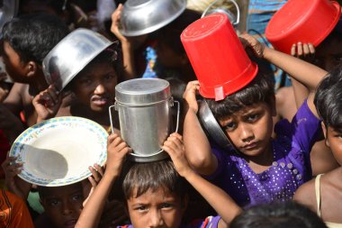 Rohingya mülteci çocukları, 2006 Ekim 'inde Bangladeş, Cox' s Bazar 'daki Palongkhali derme çatma kampında yiyecek toplamak için bekliyor. Birleşmiş Milletler Mülteciler Yüksek Komiserine (UNHCR) göre 525.000 'den fazla Rohingyalı mülteci fro firar etti