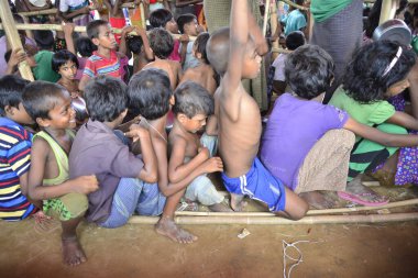 Rohingya mülteci çocukları, 2006 Ekim 'inde Bangladeş, Cox' s Bazar 'daki Palongkhali derme çatma kampında yiyecek toplamak için bekliyor. Birleşmiş Milletler Mülteciler Yüksek Komiserine (UNHCR) göre 525.000 'den fazla Rohingyalı mülteci fro firar etti