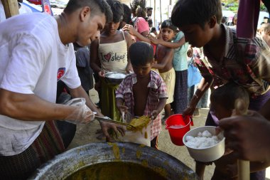 Rohingya mülteci çocukları, 2006 Ekim 'inde Bangladeş, Cox' s Bazar 'daki Palongkhali derme çatma kampında yiyecek topluyor. Birleşmiş Milletler Mülteciler Yüksek Komiserine (UNHCR) göre 525.000 'den fazla Rohingyalı mülteci Myanm' dan kaçtı