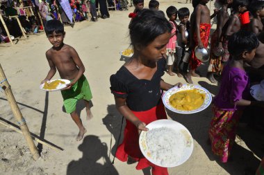 Rohingya mülteci çocukları, 2006 Ekim 'inde Bangladeş, Cox' s Bazar 'daki Palongkhali derme çatma kampında yiyecek topluyor. Birleşmiş Milletler Mülteciler Yüksek Komiserine (UNHCR) göre 525.000 'den fazla Rohingyalı mülteci Myanm' dan kaçtı
