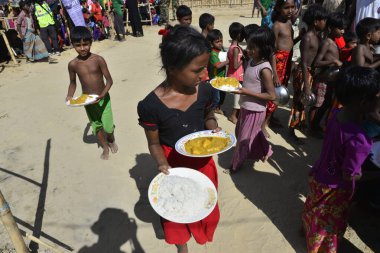 Rohingya mülteci çocukları, 2006 Ekim 'inde Bangladeş, Cox' s Bazar 'daki Palongkhali derme çatma kampında yiyecek topluyor. Birleşmiş Milletler Mülteciler Yüksek Komiserine (UNHCR) göre 525.000 'den fazla Rohingyalı mülteci Myanm' dan kaçtı