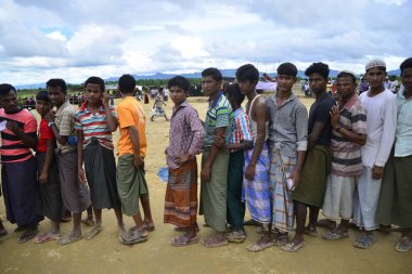 Rohingya mültecileri, 7 Ekim 2017 'de Teknaf, Bangladeş' teki Mowsuni 'de yardım almak için sırada bekliyorlar. Birleşmiş Milletler 'den yapılan açıklamaya göre, 582 bin Rohingyalı mülteci Myanmar' daki evlerini terk ederek Ağustos ayından bu yana Bangladeş 'e geldi. 