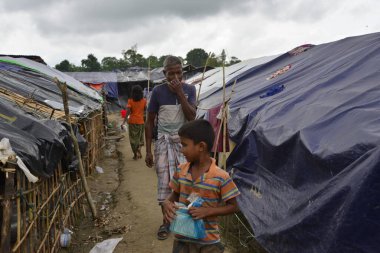 Rohingya mülteci yürüyüşleri Cox 's Bazar, Bangladeş' teki Unchiprang derme çatma kampında, 07 Eylül 2017 'de. Birleşmiş Milletler Mülteciler Yüksek Komiserine (UNHCR) göre 525.000 'den fazla Rohingyalı mülteci şiddet olayları nedeniyle Myanmar' dan kaçtı 