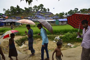 Rohingya mültecisi, 7 Eylül 2017 'de Bangladeş, Cox' s Bazar 'daki Unchiprang derme çatma kampında yağmurda yürüyor. Birleşmiş Milletler Mülteciler Yüksek Komiserine (UNHCR) göre 525.000 'den fazla Rohingyalı mülteci Myanm' dan kaçtı