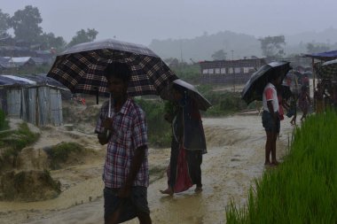 Rohingya mültecisi, 7 Eylül 2017 'de Bangladeş, Cox' s Bazar 'daki Unchiprang derme çatma kampında yağmurda yürüyor. Birleşmiş Milletler Mülteciler Yüksek Komiserine (UNHCR) göre 525.000 'den fazla Rohingyalı mülteci Myanm' dan kaçtı
