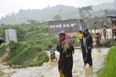 Rohingya mültecisi, 7 Eylül 2017 'de Bangladeş, Cox' s Bazar 'daki Unchiprang derme çatma kampında yağmurda yürüyor. Birleşmiş Milletler Mülteciler Yüksek Komiserine (UNHCR) göre 525.000 'den fazla Rohingyalı mülteci Myanm' dan kaçtı
