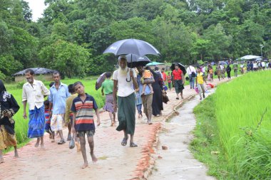 Rohingya mültecisi, 7 Eylül 2017 'de Bangladeş, Cox' s Bazar 'daki Unchiprang derme çatma kampında yağmurda yürüyor. Birleşmiş Milletler Mülteciler Yüksek Komiserine (UNHCR) göre 525.000 'den fazla Rohingyalı mülteci Myanm' dan kaçtı