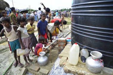 Rohingya çocukları, 7 Eylül 2017 tarihinde Bangladeş, Cox 's Bazar' daki Unchiprnag Makeshift Kampı 'ndaki WaterTank' ten içme suyu toplarlar. Birleşmiş Milletler Mülteciler Yüksek Komiserine (UNHCR) göre 525 binden fazla Rohingya hakemi
