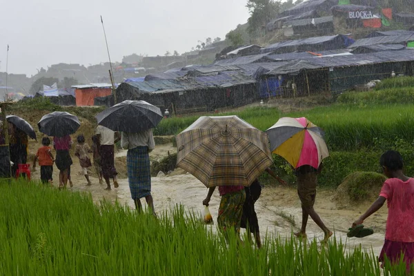 Rohingya mültecisi, 7 Eylül 2017 'de Bangladeş, Cox' s Bazar 'daki Unchiprang derme çatma kampında yağmurda yürüyor. Birleşmiş Milletler Mülteciler Yüksek Komiserine (UNHCR) göre 525.000 'den fazla Rohingyalı mülteci Myanm' dan kaçtı