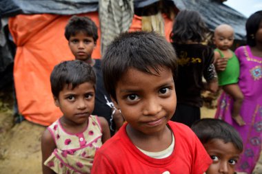 Rohingya çocukları 8 Ekim 2017 'de Cox' s Bazar, Bangladeş 'teki Thangkhali derme çatma kampında poz verdiler. Birleşmiş Milletler Mülteciler Yüksek Komiserine (UNHCR) göre şiddet uygulamak amacıyla 525 binden fazla Rohingya mültecisi Myanmar 'dan kaçtı