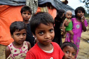 Rohingya çocukları 8 Ekim 2017 'de Cox' s Bazar, Bangladeş 'teki Thangkhali derme çatma kampında poz verdiler. Birleşmiş Milletler Mülteciler Yüksek Komiserine (UNHCR) göre şiddet uygulamak amacıyla 525 binden fazla Rohingya mültecisi Myanmar 'dan kaçtı