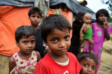Rohingya çocukları 8 Ekim 2017 'de Cox' s Bazar, Bangladeş 'teki Thangkhali derme çatma kampında poz verdiler. Birleşmiş Milletler Mülteciler Yüksek Komiserine (UNHCR) göre şiddet uygulamak amacıyla 525 binden fazla Rohingya mültecisi Myanmar 'dan kaçtı