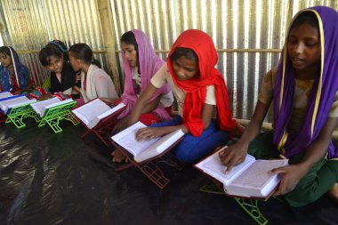 Rohingya Çocukları Kuran 'ı 10 Ekim 2017' de Bangladeş, Cox 's Bazar' daki Balukhali derme çatma kampında bir Madrasa 'da öğreniyorlar. 9 Ekim 'de Myanmar' da binlerce Rohingya 'nın şiddetten kaçması Bangladeş' e akın etti.