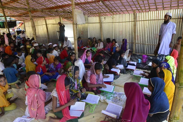 Rohingya Çocukları Kuran 'ı 10 Ekim 2017' de Bangladeş, Cox 's Bazar' daki Balukhali derme çatma kampında bir Madrasa 'da öğreniyorlar. 9 Ekim 'de Myanmar' da binlerce Rohingya 'nın şiddetten kaçması Bangladeş' e akın etti.