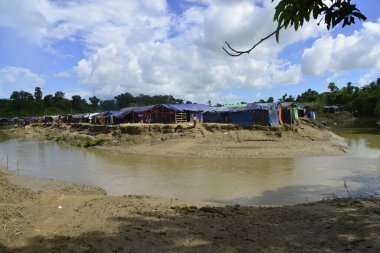 Rohingya mültecileri 10 Ekim 2017 'de Tombru Bandarban' ın Myanmar ve Bangladeş sınırları arasındaki tarafsız bölge yakınlarındaki bir yerleşim bölgesinin yanındaki kanalı geçtiler. Myanmar 'da şiddetten kaçan binlerce Rohingya Ban' a akın etti