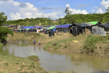 Rohingya mültecileri 10 Ekim 2017 'de Tombru Bandarban' ın Myanmar ve Bangladeş sınırları arasındaki tarafsız bölge yakınlarındaki bir yerleşim bölgesinin yanındaki kanalı geçtiler. Myanmar 'da şiddetten kaçan binlerce Rohingya Ban' a akın etti