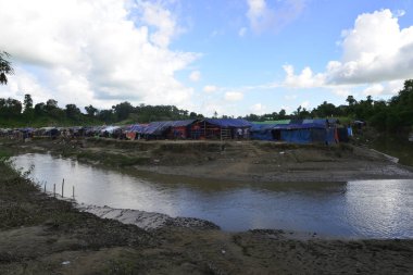 Rohingya mültecileri 10 Ekim 2017 'de Tombru Bandarban' ın Myanmar ve Bangladeş sınırları arasındaki tarafsız bölge yakınlarındaki bir yerleşim bölgesinin yanındaki kanalı geçtiler. Myanmar 'da şiddetten kaçan binlerce Rohingya Ban' a akın etti
