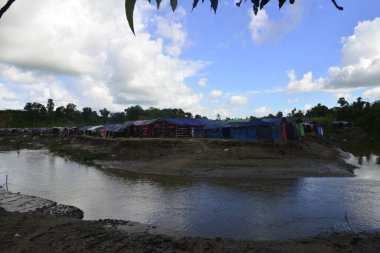 Rohingya mültecileri 10 Ekim 2017 'de Tombru Bandarban' ın Myanmar ve Bangladeş sınırları arasındaki tarafsız bölge yakınlarındaki bir yerleşim bölgesinin yanındaki kanalı geçtiler. Myanmar 'da şiddetten kaçan binlerce Rohingya Ban' a akın etti