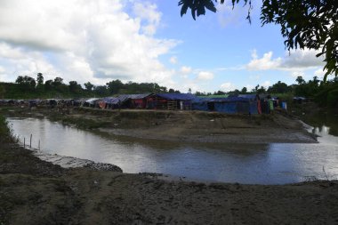 Rohingya mültecileri 10 Ekim 2017 'de Tombru Bandarban' ın Myanmar ve Bangladeş sınırları arasındaki tarafsız bölge yakınlarındaki bir yerleşim bölgesinin yanındaki kanalı geçtiler. Myanmar 'da şiddetten kaçan binlerce Rohingya Ban' a akın etti