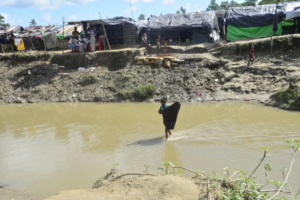 Rohingya mültecileri 10 Ekim 2017 'de Tombru Bandarban' ın Myanmar ve Bangladeş sınırları arasındaki tarafsız bölge yakınlarındaki bir yerleşim bölgesinin yanındaki kanalı geçtiler. Myanmar 'da şiddetten kaçan binlerce Rohingya Ban' a akın etti