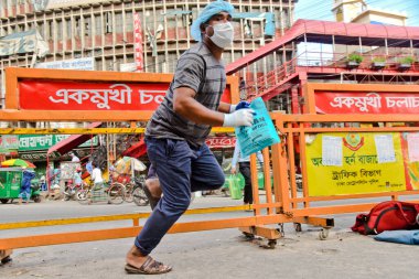 Bangladeş, Dhaka 'da 16 Haziran 2020' de meydana gelen koronavirüs salgını sırasında Facemaske takan insanlar yoldan yasadışı olarak geçiyorlar.