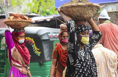 Bangladeş, Dhaka 'daki koronavirüs salgını sırasında, 13 Haziran 2020' de bir yol inşaatında maske takan günlük görevliler çalışıyor. 
