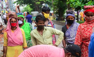 Bangladeş, Dhaka 'daki koronavirüs salgını sırasında, 13 Haziran 2020' de bir yol inşaatında maske takan günlük görevliler çalışıyor. 