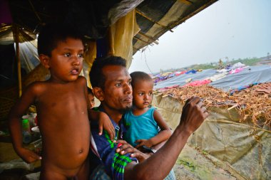 2006 Eylül 'ünde Bangladeş, Cox' s Bazar 'daki Thengkhali derme çatma kampında bir Rohingya mülteci aile üyesi oturuyor. Ağustos ayında komşu Myanmar 'daki askeri baskından bu yana 600 binden fazla Rohingya Bangladeş' e geldi.