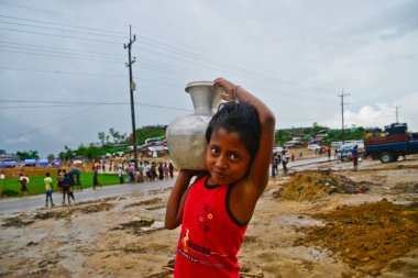 Bir Rohingya mültecisi çocukları Bangladeş 'in Cox Çarşısı' ndaki Thengkhali derme çatma kampında 2006 Eylül 'ünde su taşır. Ağustos ayında komşu Myanmar 'a yapılan askeri baskından bu yana 600 binden fazla Rohingya Bangladeş' e geldi.