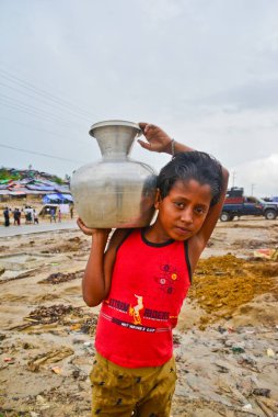 Bir Rohingya mültecisi çocukları Bangladeş 'in Cox Çarşısı' ndaki Thengkhali derme çatma kampında 2006 Eylül 'ünde su taşır. Ağustos ayında komşu Myanmar 'a yapılan askeri baskından bu yana 600 binden fazla Rohingya Bangladeş' e geldi.