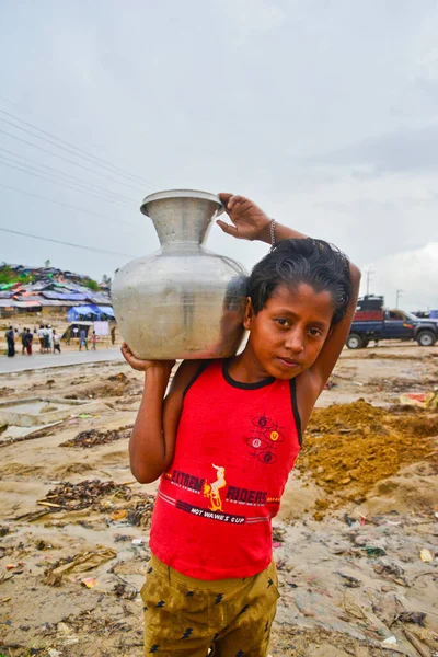 Bir Rohingya mültecisi çocukları Bangladeş 'in Cox Çarşısı' ndaki Thengkhali derme çatma kampında 2006 Eylül 'ünde su taşır. Ağustos ayında komşu Myanmar 'a yapılan askeri baskından bu yana 600 binden fazla Rohingya Bangladeş' e geldi.