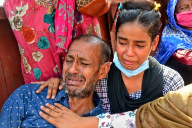 29 Haziran 2020 'de Bangladeş' in Dhaka kentindeki Buriganga Nehri 'nde alabora olan fırlatmanın ardından kurtarılan kurbanların cesetlerinin ardından ağlayan bir kurbanın yakınları görülüyor. Sadarghat feribotunda bir feribot alabora olup battıktan sonra en az 30 kişi öldü ve bir düzinesi kayıp. 