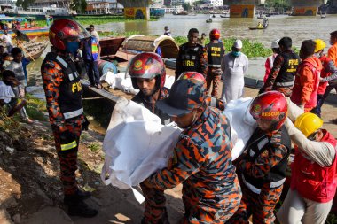 Kurtarma ekipleri 29 Haziran 2020 'de Bangladeş' in Dhaka kentindeki Buriganga Nehri 'nde alabora olan fırlatmanın ardından kurbanların cesetlerini taşıyorlar. Dhaka Coll 'daki Sadarghat feribot terminalinde bir feribot alabora olup battıktan sonra en az 30 kişi öldü ve bir düzinesi kayıp.