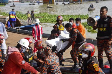 Kurtarma ekipleri 29 Haziran 2020 'de Bangladeş' in Dhaka kentindeki Buriganga Nehri 'nde alabora olan fırlatmanın ardından kurbanların cesetlerini taşıyorlar. Dhaka Coll 'daki Sadarghat feribot terminalinde bir feribot alabora olup battıktan sonra en az 30 kişi öldü ve bir düzinesi kayıp.