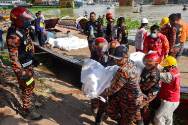 Kurtarma ekipleri 29 Haziran 2020 'de Bangladeş' in Dhaka kentindeki Buriganga Nehri 'nde alabora olan fırlatmanın ardından kurbanların cesetlerini taşıyorlar. Dhaka Coll 'daki Sadarghat feribot terminalinde bir feribot alabora olup battıktan sonra en az 30 kişi öldü ve bir düzinesi kayıp.