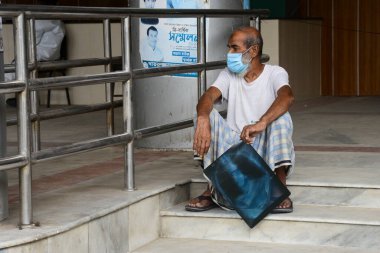 Dhaka, Bangladeş 'teki koronavirüs salgını sırasında Dhaka Tıp Fakültesi Hastanesi' nin önünde 3 Temmuz 2020 tarihinde bir hasta doktor tavsiyesi için röntgen filmiyle bekliyor..