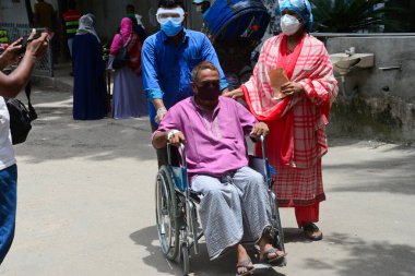 Bir hasta, Bangladeş, Dhaka 'daki koronavirüs salgını sırasında tedavi görmek için 3 Temmuz 2020' de Dhaka Tıp Fakültesi Hastanesi 'nin önünde akrabalarıyla birlikte bekliyor..