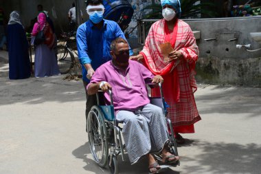 Bir hasta, Bangladeş, Dhaka 'daki koronavirüs salgını sırasında tedavi görmek için 3 Temmuz 2020' de Dhaka Tıp Fakültesi Hastanesi 'nin önünde akrabalarıyla birlikte bekliyor..