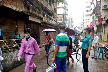 Polis memurları, Bangladeş 'in başkenti Dhaka' daki Wari 'de 4 Temmuz 2020' de hükümet tarafından azami enfeksiyon riski bulunan koronavirüs kırmızı bölgede devriye gezerken evlerinde kalmaları gerektiğinin farkında..